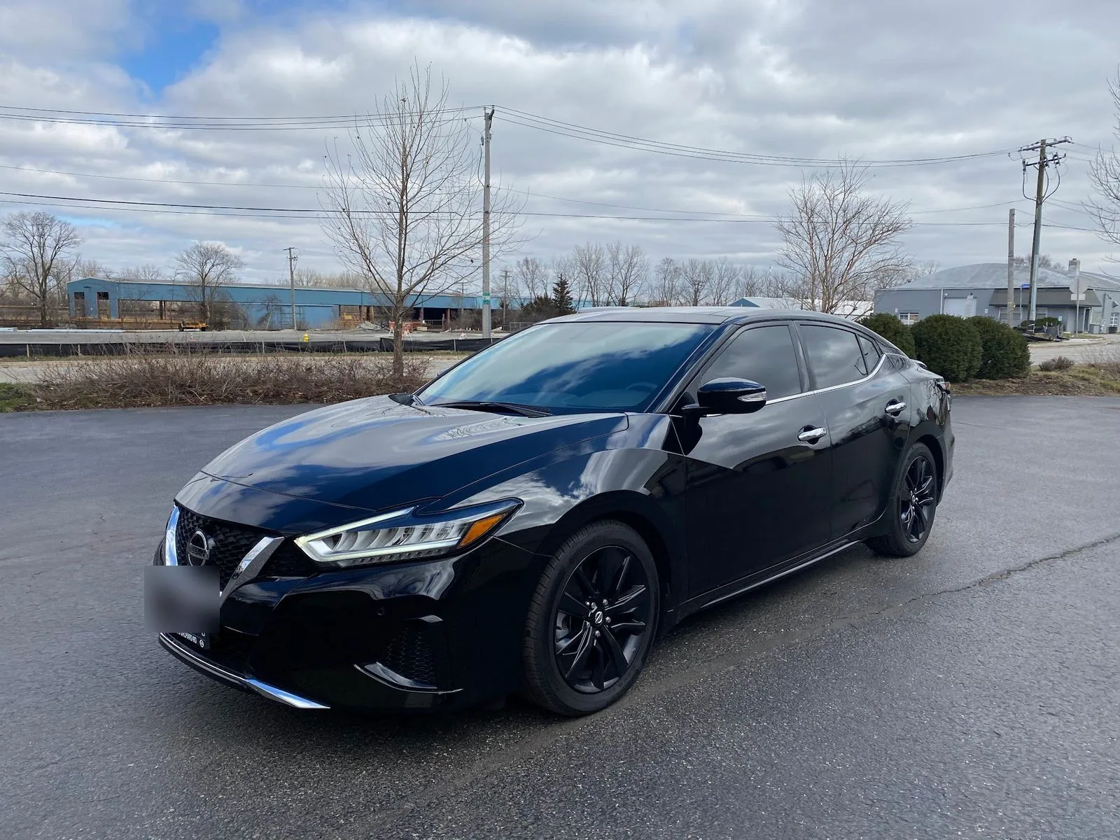 Black Nissan Maxima with tinted glass, parked outside the MES shop
